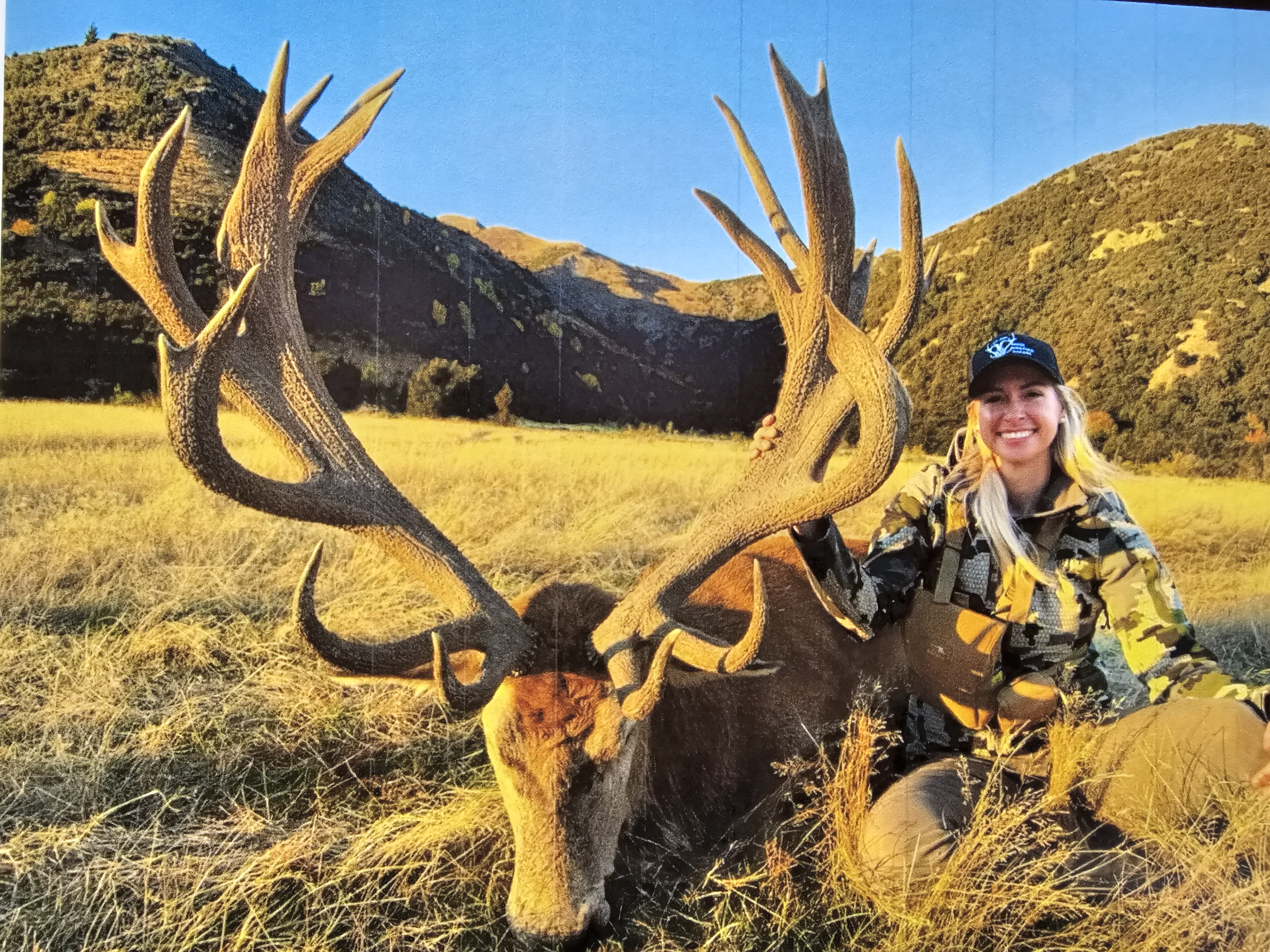 Hunter with trophy elk in a Colorado mountain meadow